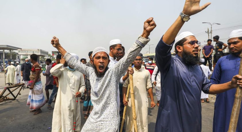 Activist from Hefazat-e Islam shouts slogans as with others block a road during a nationwide strike following deadly clashes with police over Indian Prime Minister Narendra Modi’s visit, in Narayanganj, about 16 km southeast of Dhaka on March 28, 2021. (Photo by Ahmed Salahuddin/NurPhoto)