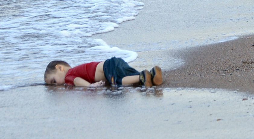epa04910104 Washed up body of a refugee child who drowned during a failed attempt to sail to the Greek island of Kos, at the shore in the coastal town of Bodrum, Mugla city, Turkey, 02 September 2015. At least 11 Syrian migrants died in boat sank after leaving Turkey for the Greek island of Kos.  EPA/DOGAN NEWS AGENCY ATTENTION EDITORSgraphic content 
ATTENTION EDITORS: PICTURE CONTAINS GRAPHIC CONTENT ; TURKEY OUT